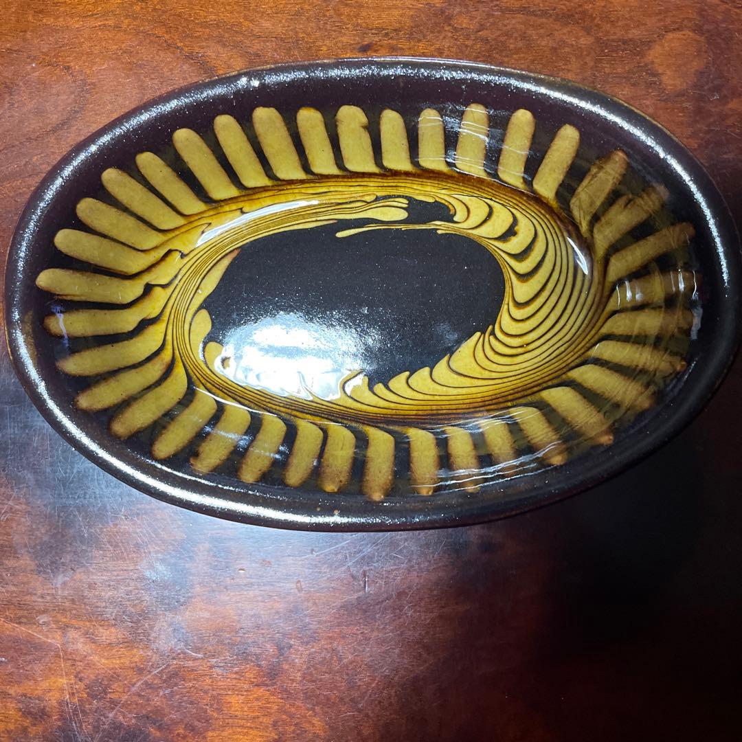 湯町窯陶器の楕円形皿 黒と黄の渦巻き模様