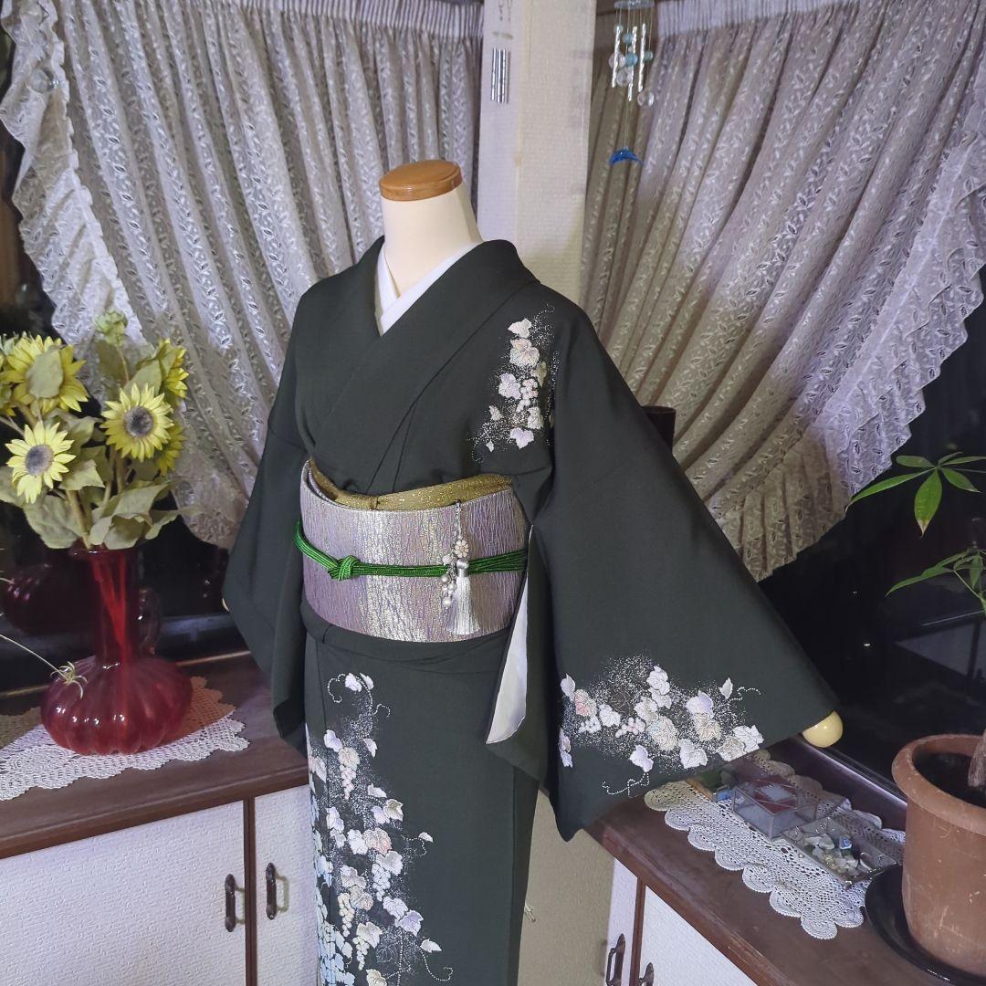 落款が入ります、青丹色の地に煌めく葡萄柄が繊細な美しさを見せる正絹訪問着です