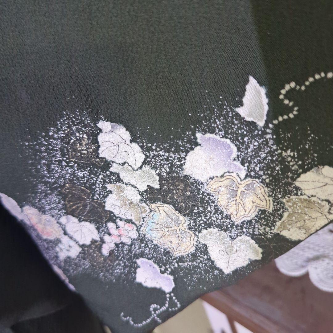 落款が入ります、青丹色の地に煌めく葡萄柄が繊細な美しさを見せる正絹訪問着です