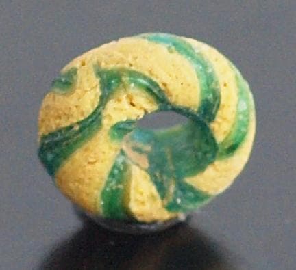 クリアな青緑に鮮やか黄で、回転する輪状モチーフを描くモザイク平玉　前後～6C頃の
