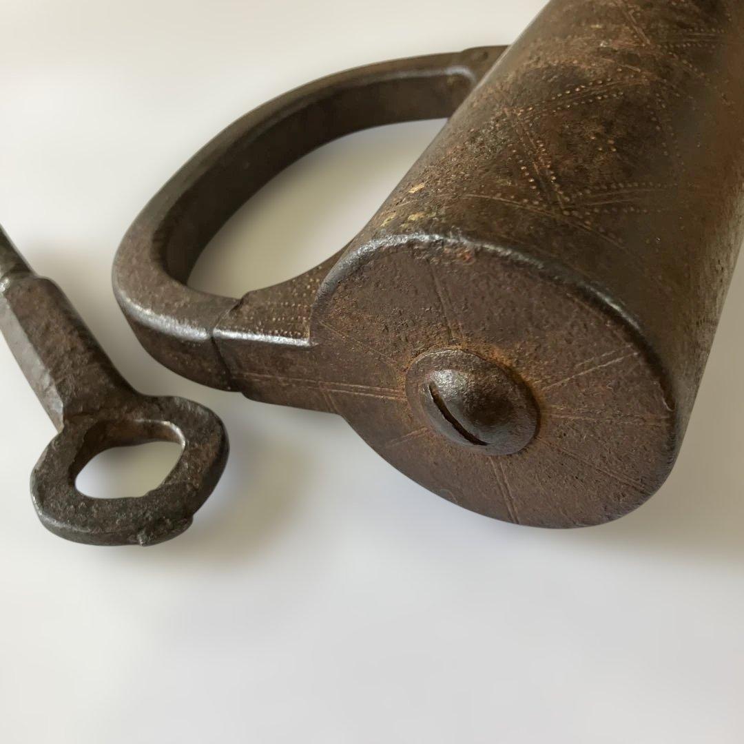 アンティークな鉄製スクリュー式円筒型南京錠（表面には点描幾何学模様）