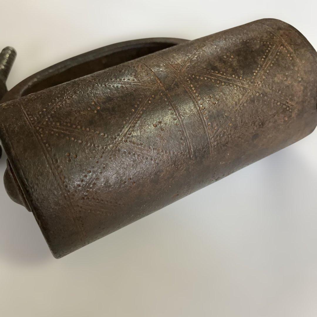 アンティークな鉄製スクリュー式円筒型南京錠（表面には点描幾何学模様）