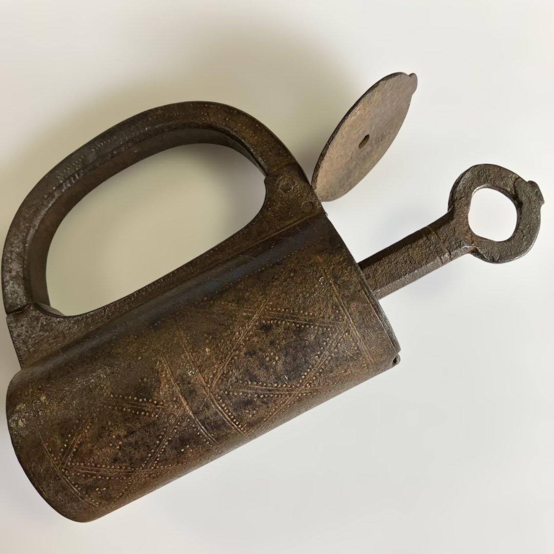 アンティークな鉄製スクリュー式円筒型南京錠（表面には点描幾何学模様）