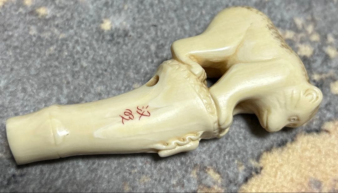 根付 竹の子に止まりバッタを見つめる猿の姿をしている根付