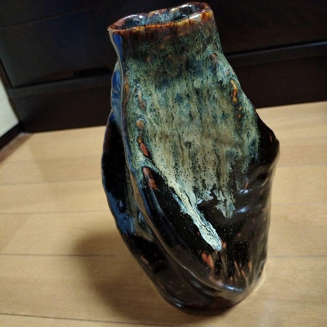 黒色地に青と白と茶の陶器花瓶