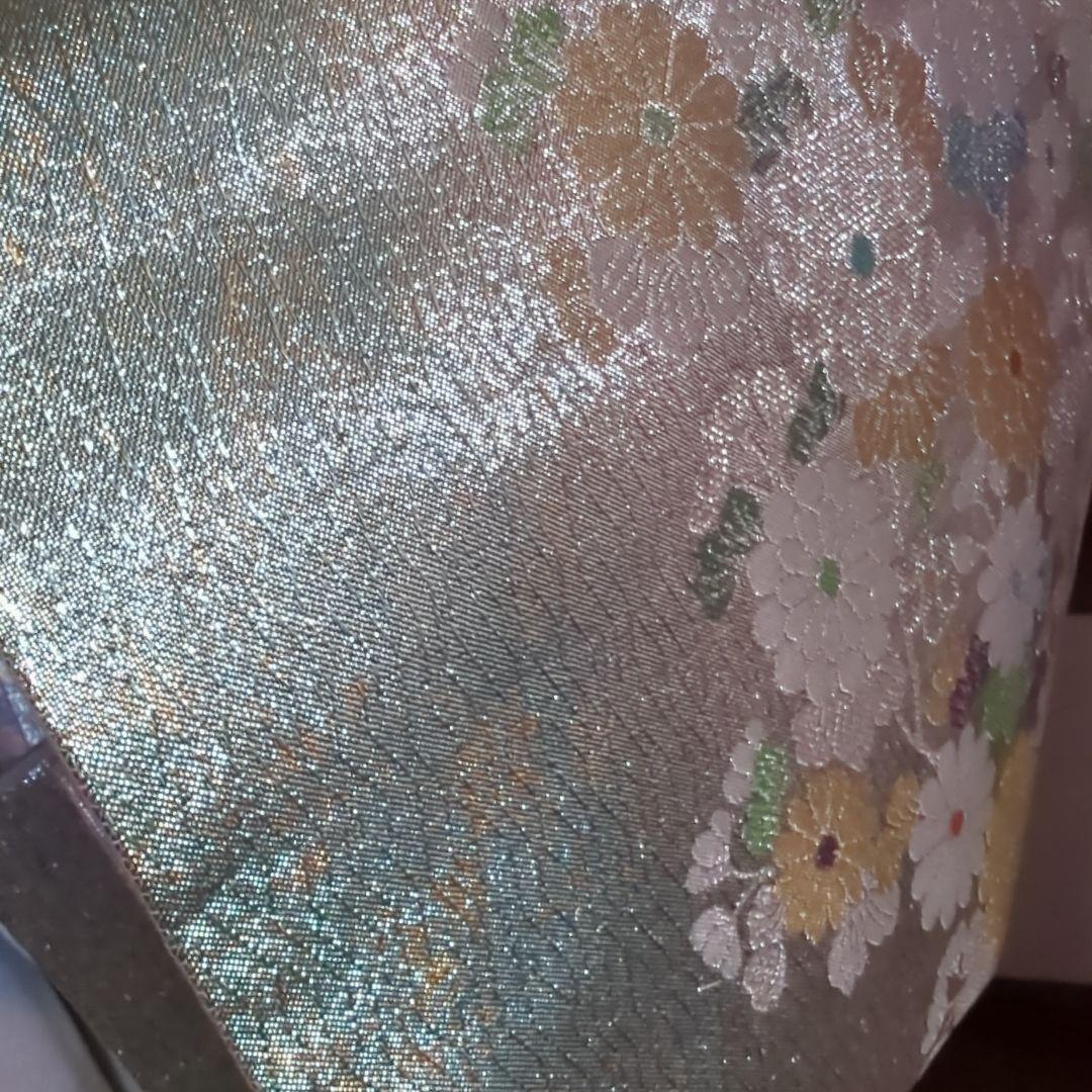 虹色に煌めくシルバーの地に、菊の花が艶やかに咲く、美しい正絹袋帯です