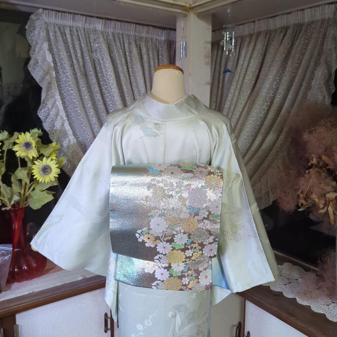 虹色に煌めくシルバーの地に、菊の花が艶やかに咲く、美しい正絹袋帯です