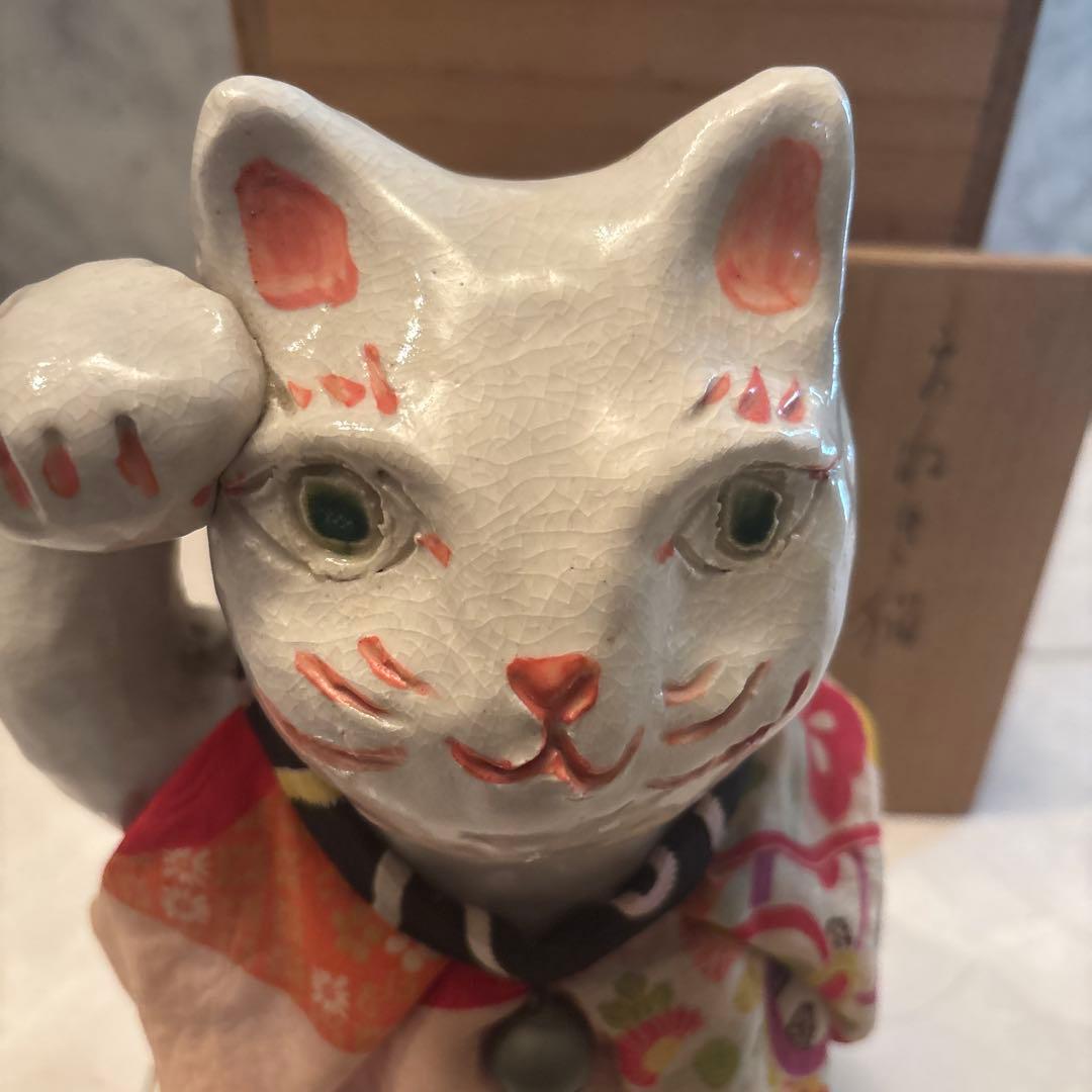 作家さんによる大きな瞳でにっこりと笑う着物の前掛けも美しい招き猫