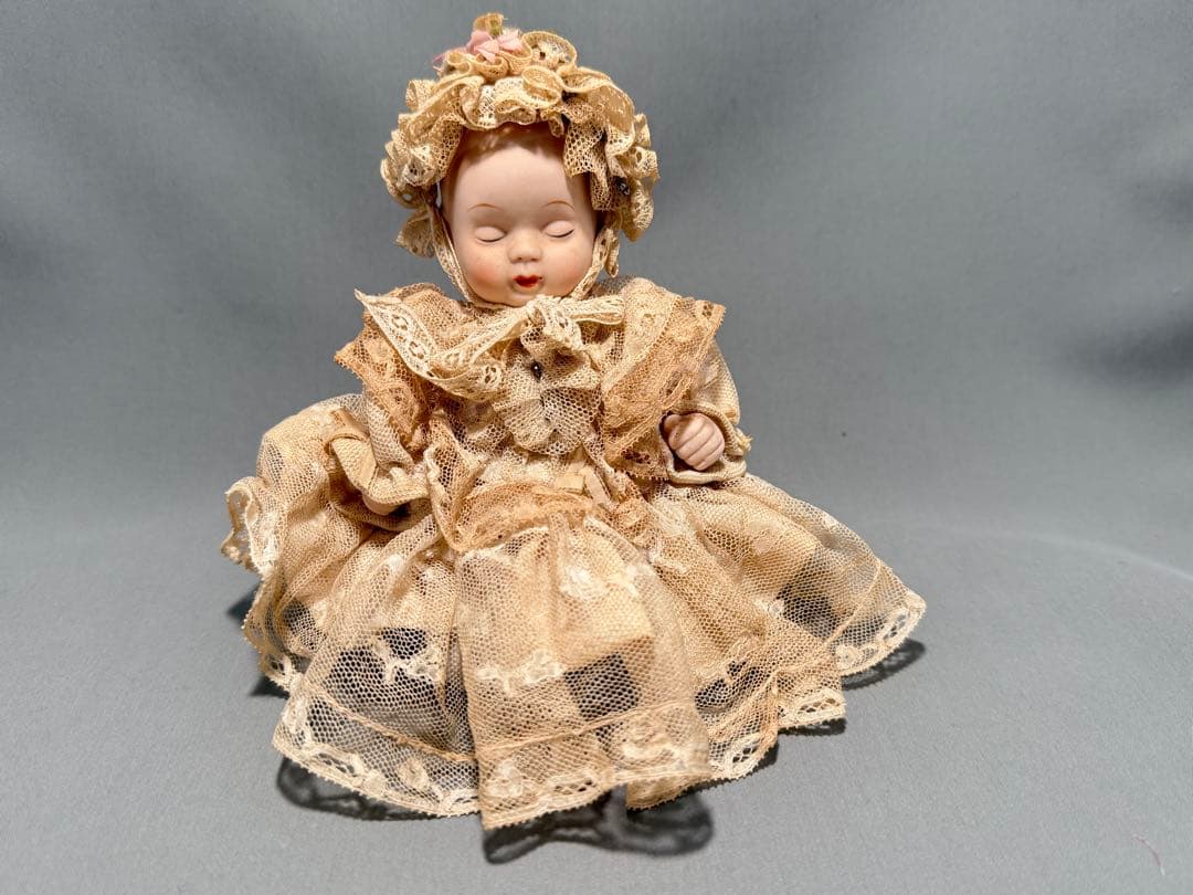 レースドレスをまとったベビーのアンティークドール。陶器製2フェイス
