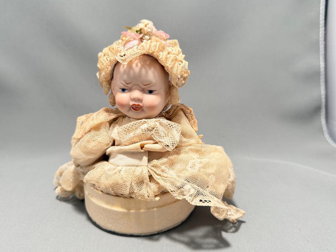 レースドレスをまとったベビーのアンティークドール。陶器製2フェイス