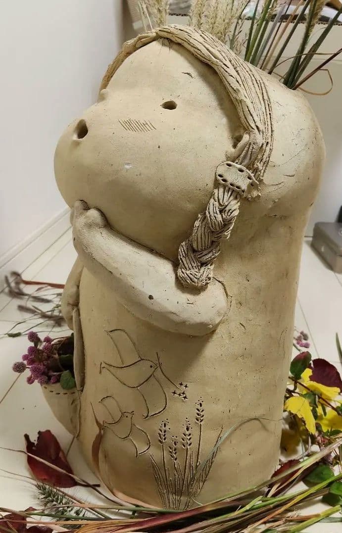 素焼き陶器·花かごを持った三つ編みの女の子と、ツノが愛らしい幼い鬼っ子