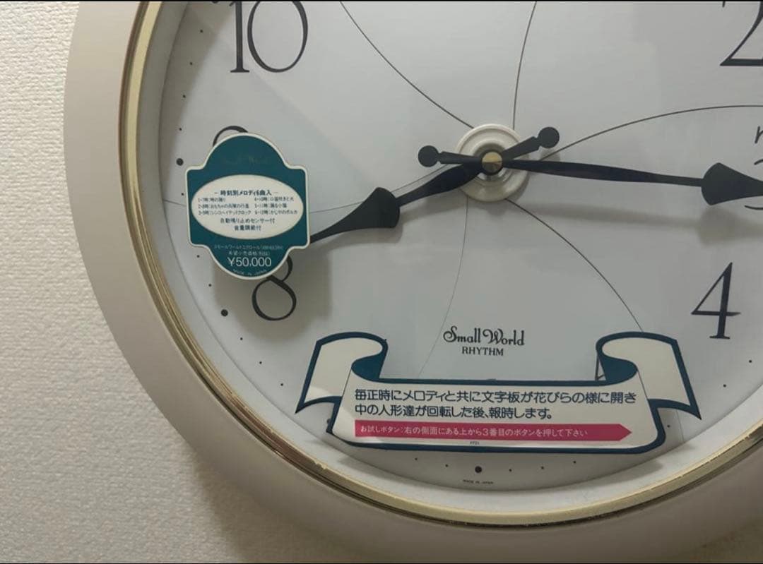 Small World 花の形状 掛時計 動く人形付き