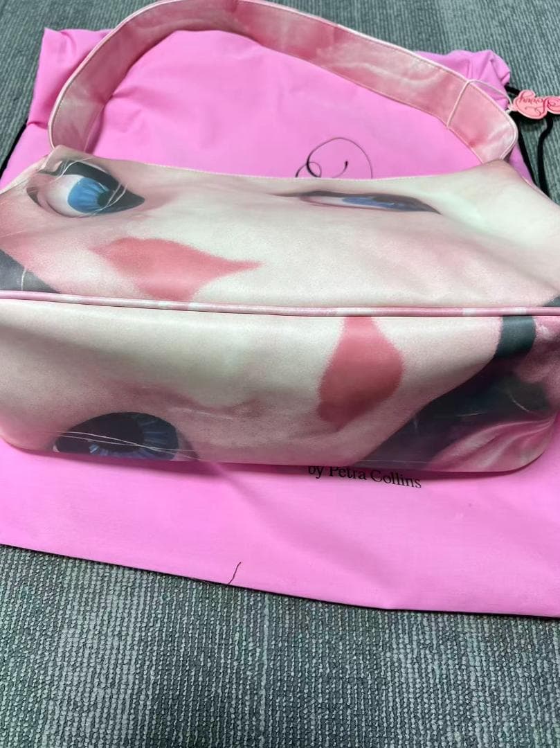 ピンクの顔プリントバッグ by Petra Collins