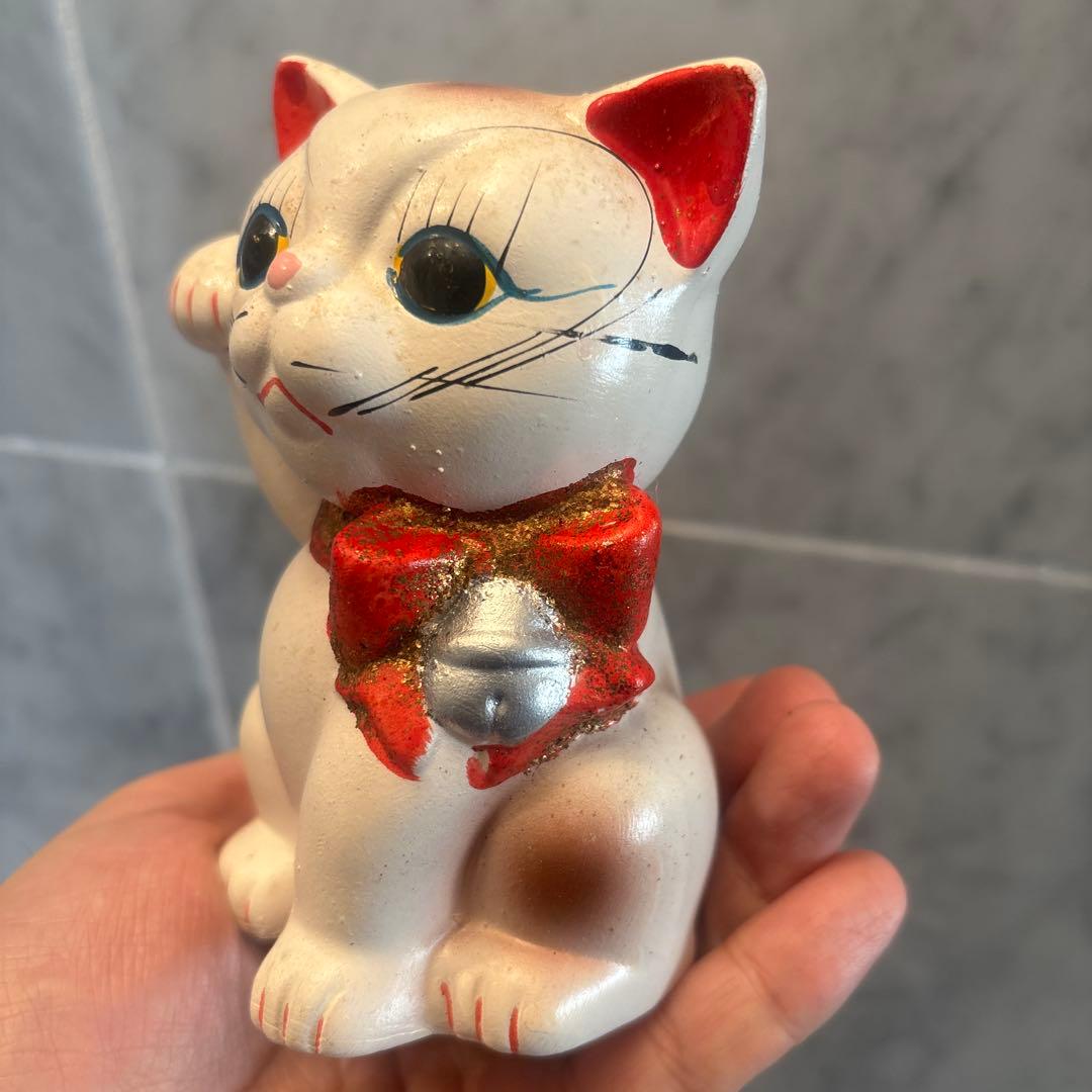 アンティーク大きな瞳や長いヒゲ、まつ毛が美しく、大きなリボンも可愛い招き猫